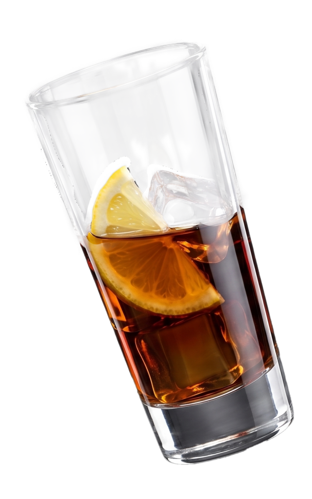 Ein schräg stehendes Glas mit dunklem Getränk, Eiswürfeln und Zitronenscheiben vor grauem Hintergrund wirkt frisch und elegant im Licht.