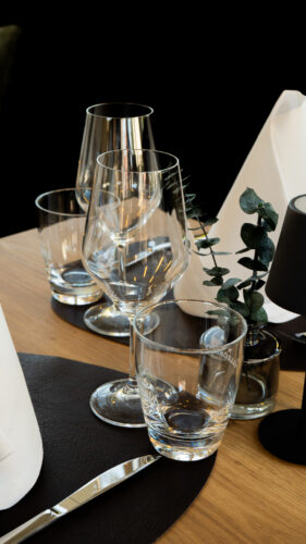 Elegante Glaswaren mit Weingläsern und Trinkgläsern auf einem gedeckten Restauranttisch bei DIVINO in Hallbergmoos
